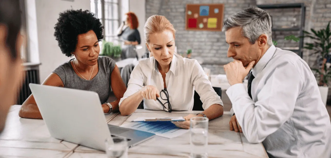 Colleagues reviewing papers at a laptop