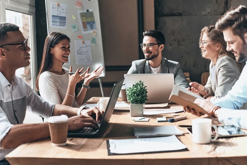 A team brainstorming around a laptop