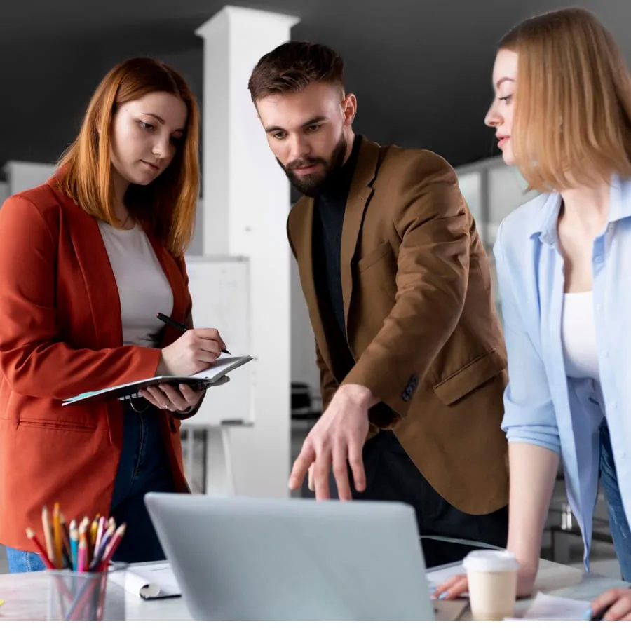 Colleagues meeting around a laptop