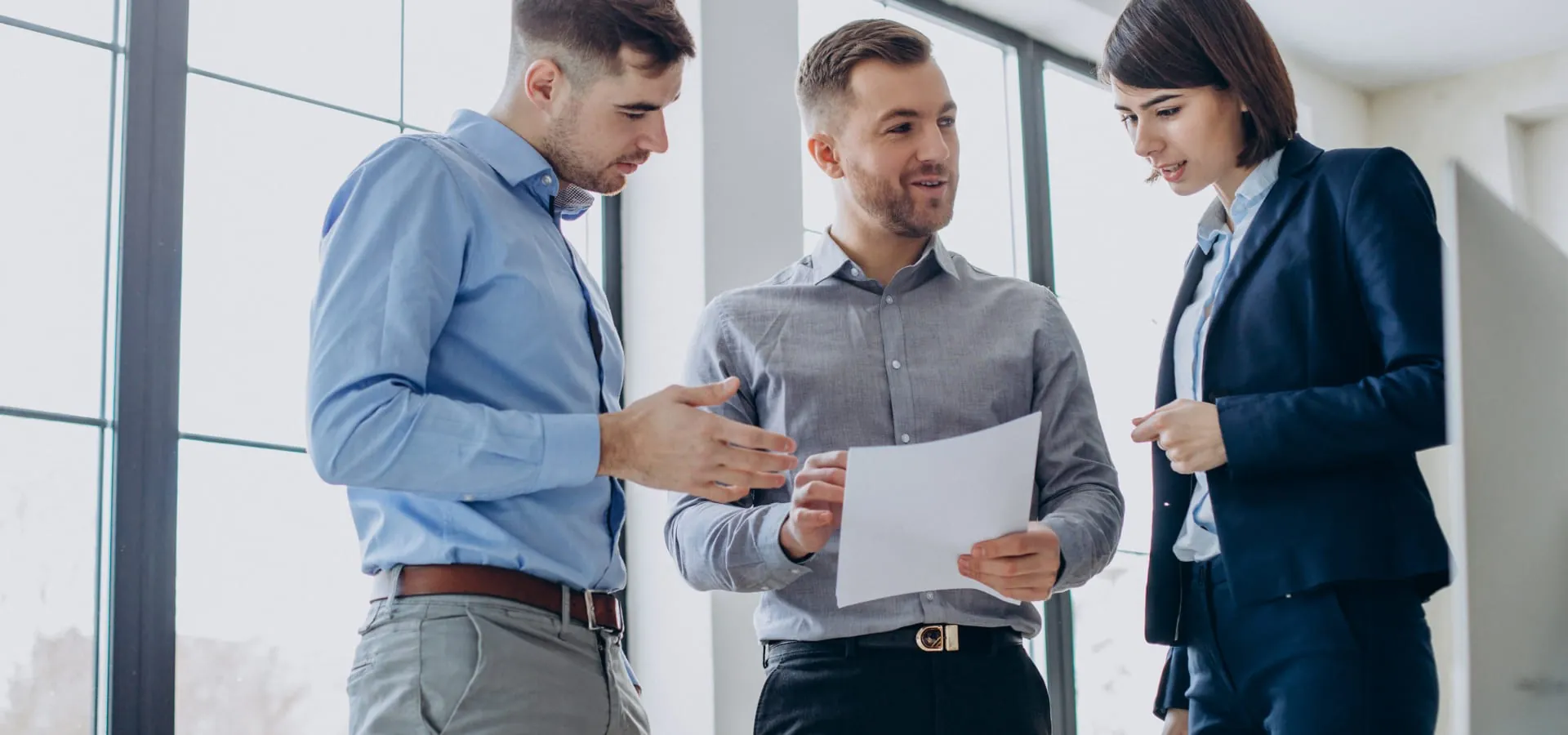 Three colleagues talking over a document