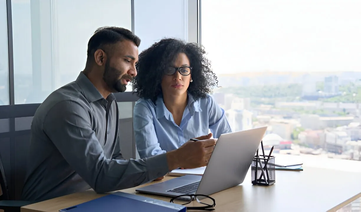 Two colleagues going over figures on a laptop