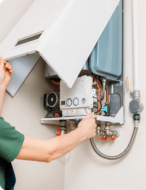 A technician servicing a wall-mounted water heater