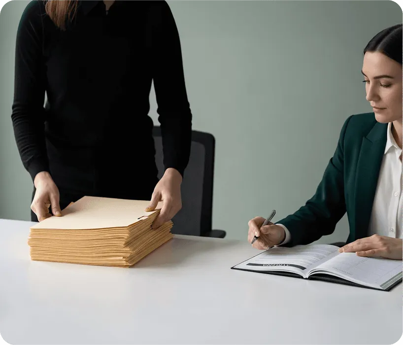 Two people going through paperwork at an office desk