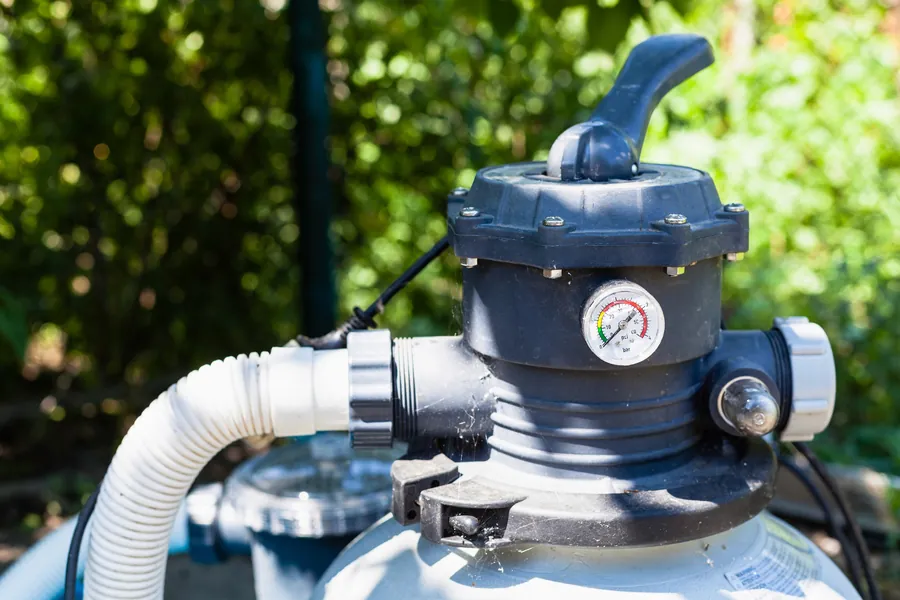 A pool sand filter with its multiport valve and hoses