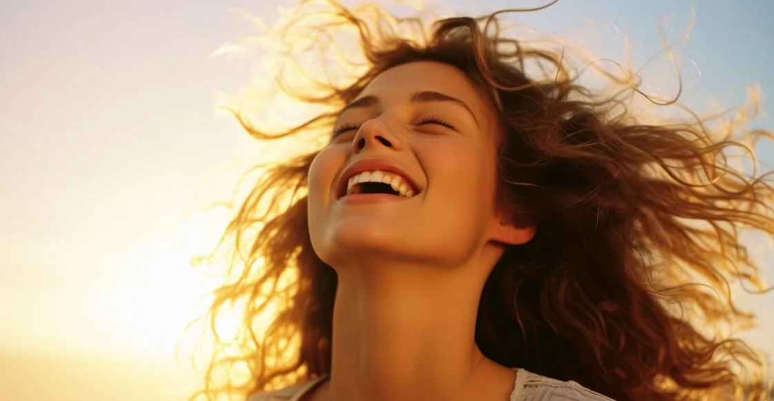 A woman laughing with her face in the sun