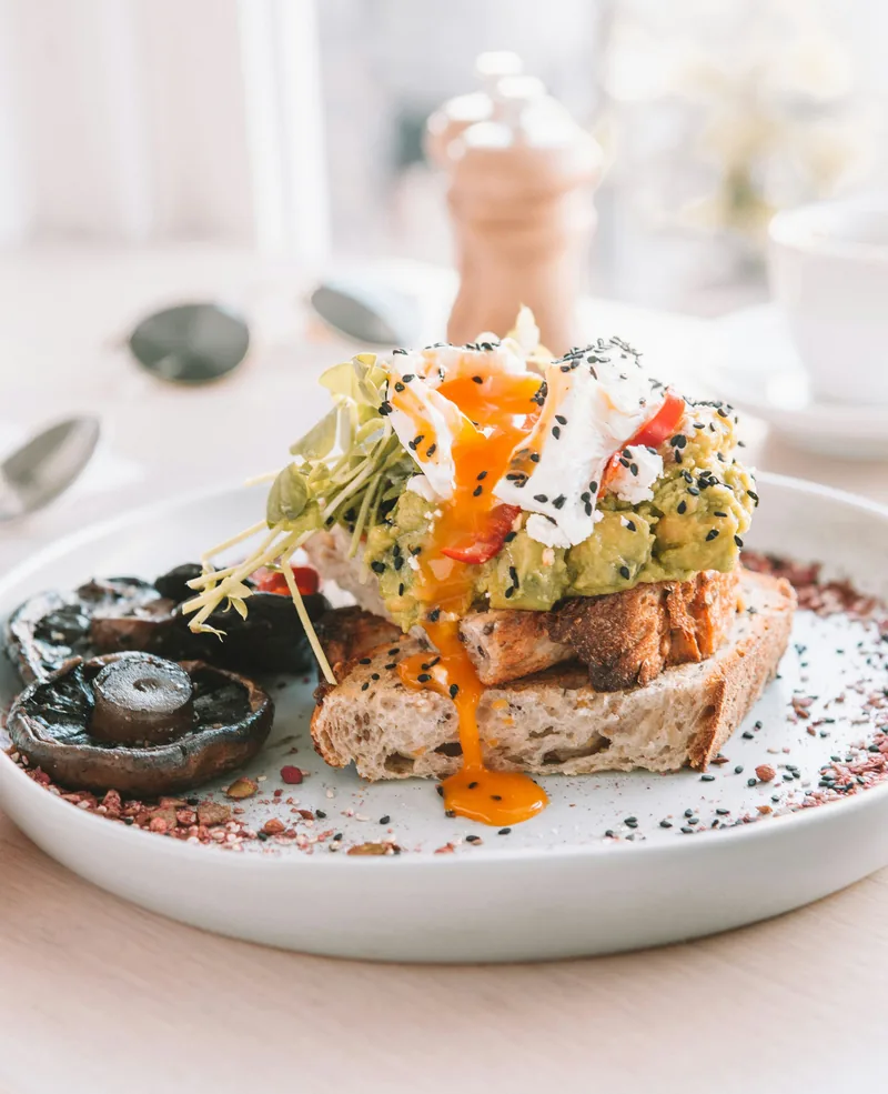 Avocado toast with a runny poached egg and mushrooms