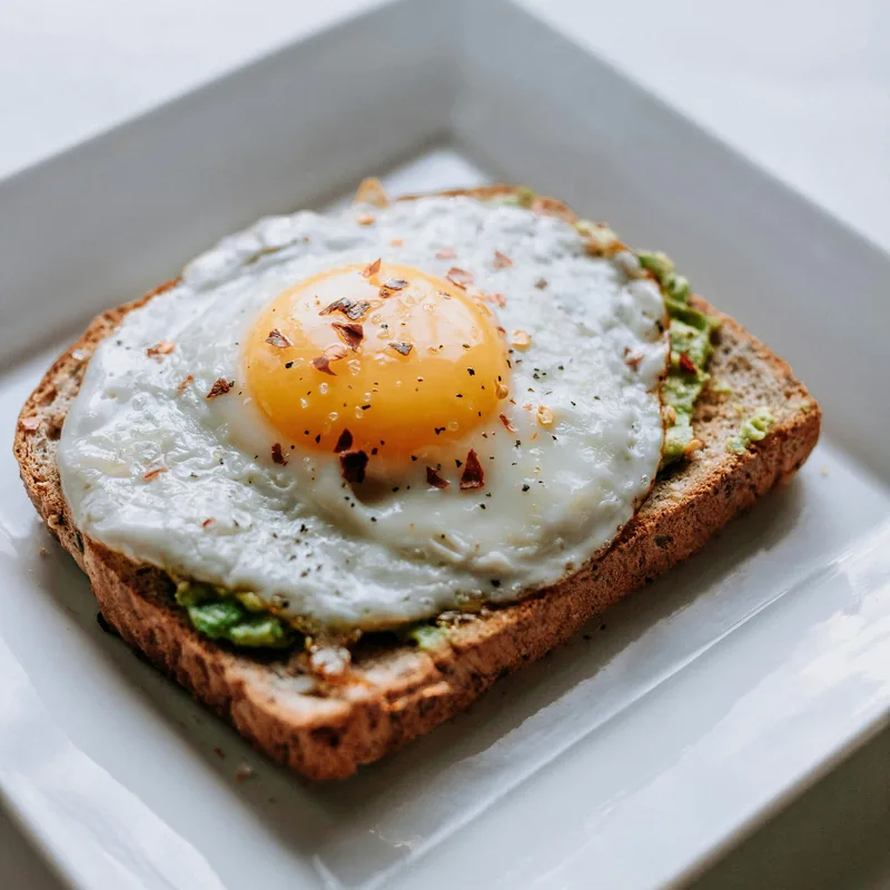 A fried egg on smashed avocado toast