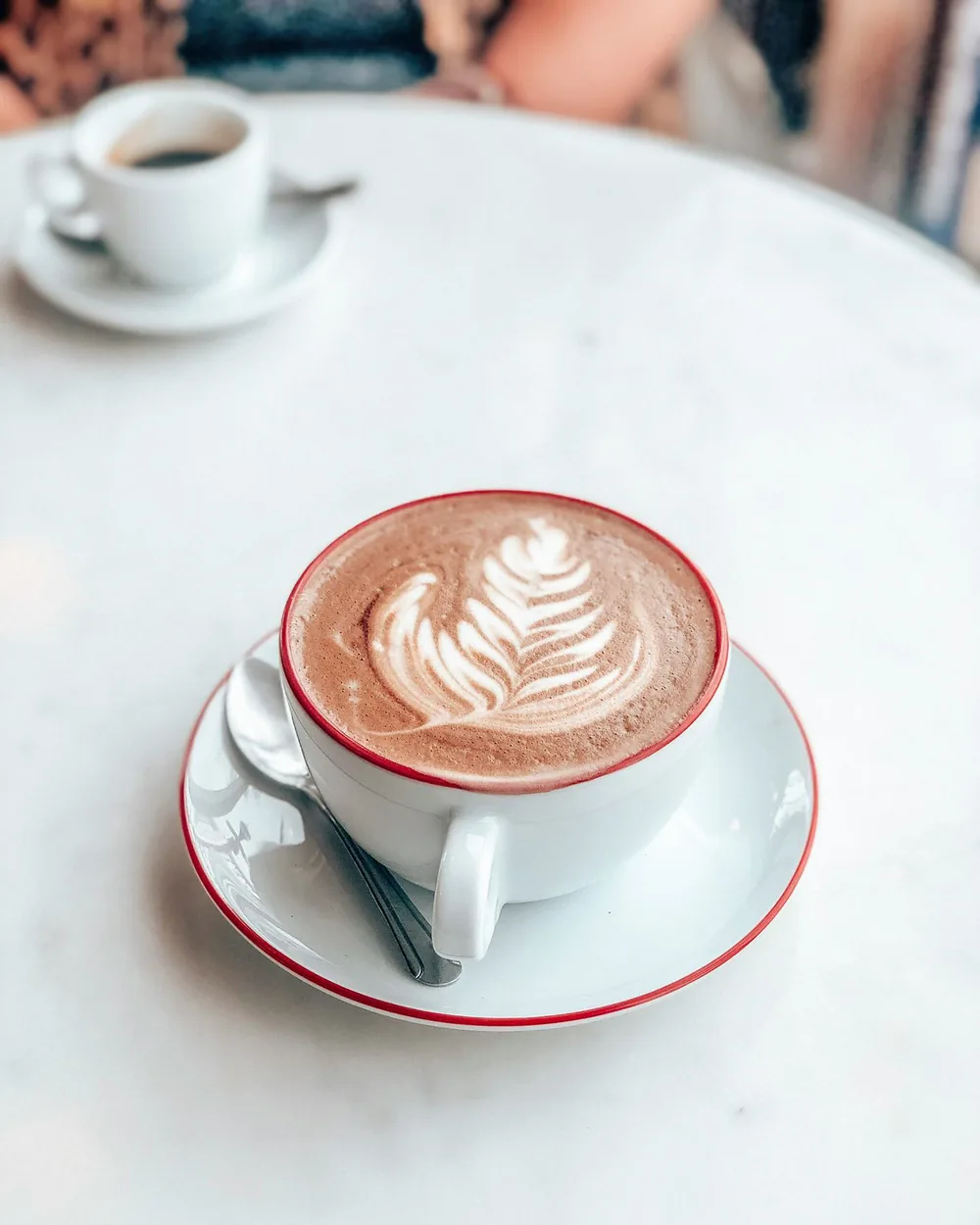 A cappuccino with latte art in a white cup