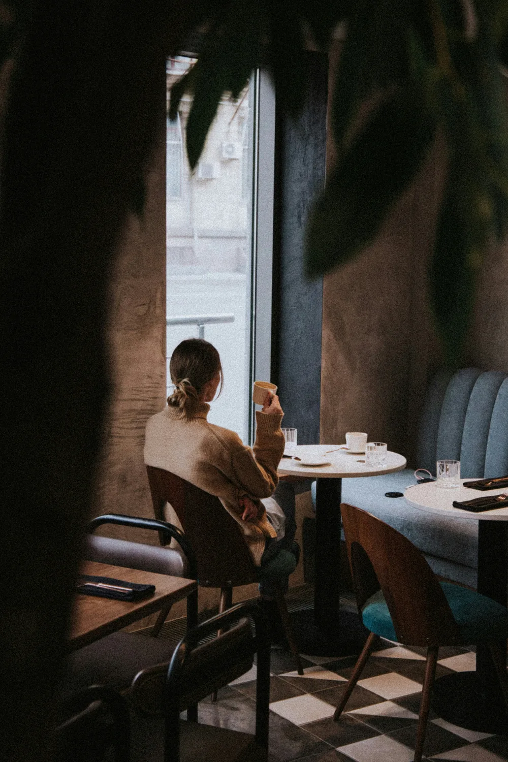 A guest seated by the window in a softly lit café