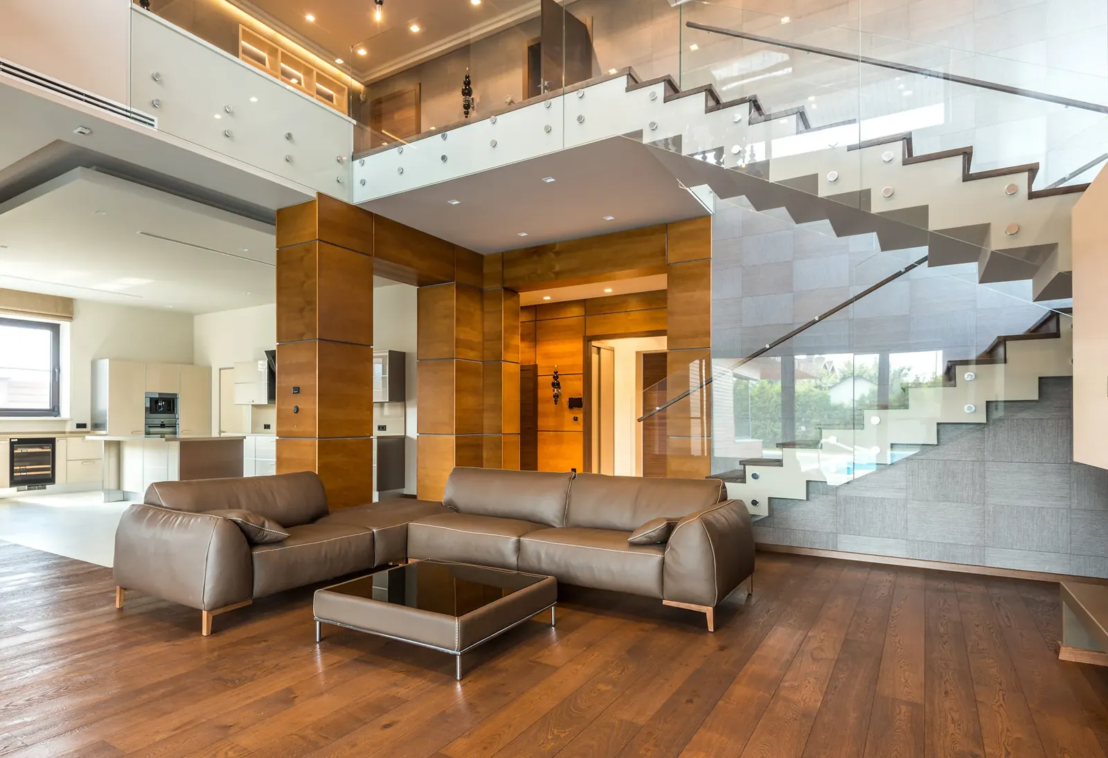 A living room with leather sofas and a staircase