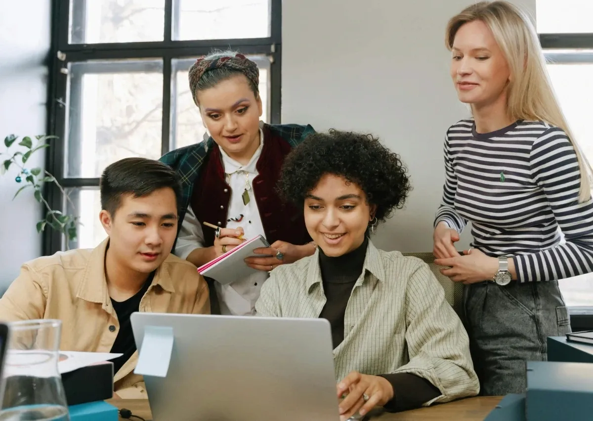 Colleagues gathered around a laptop