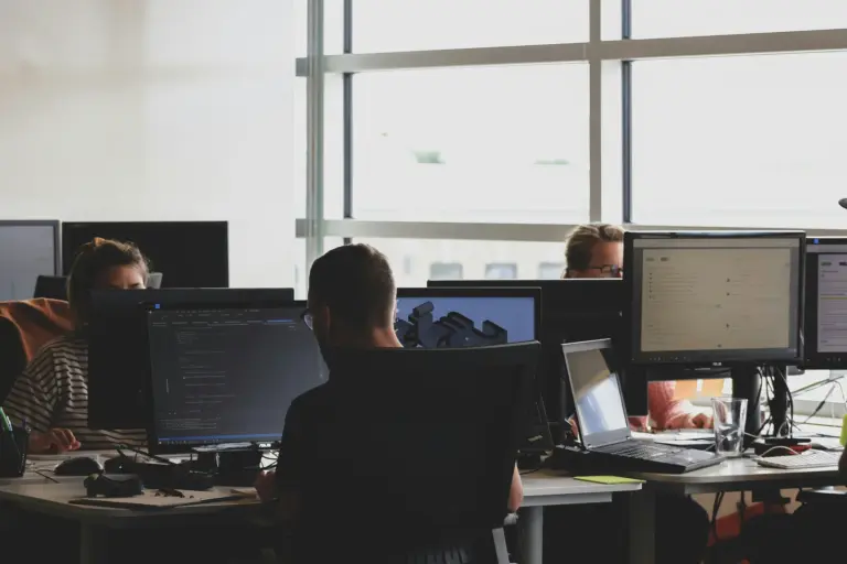 People working at computer monitors in a shared office