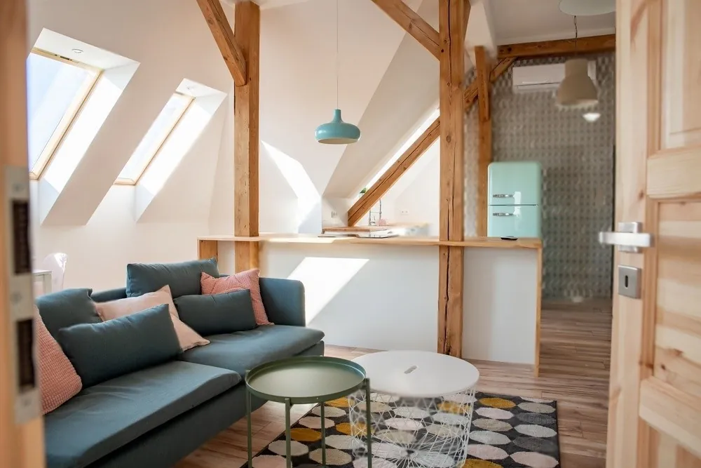 An attic lounge with a teal sofa