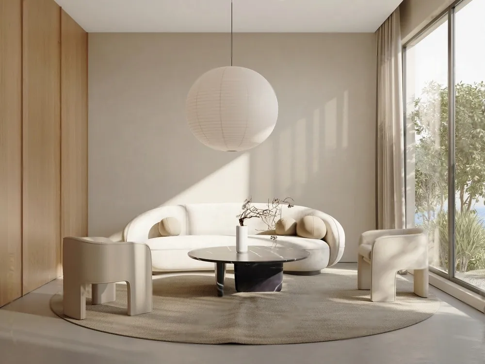 A cream curved sofa under a paper pendant lamp