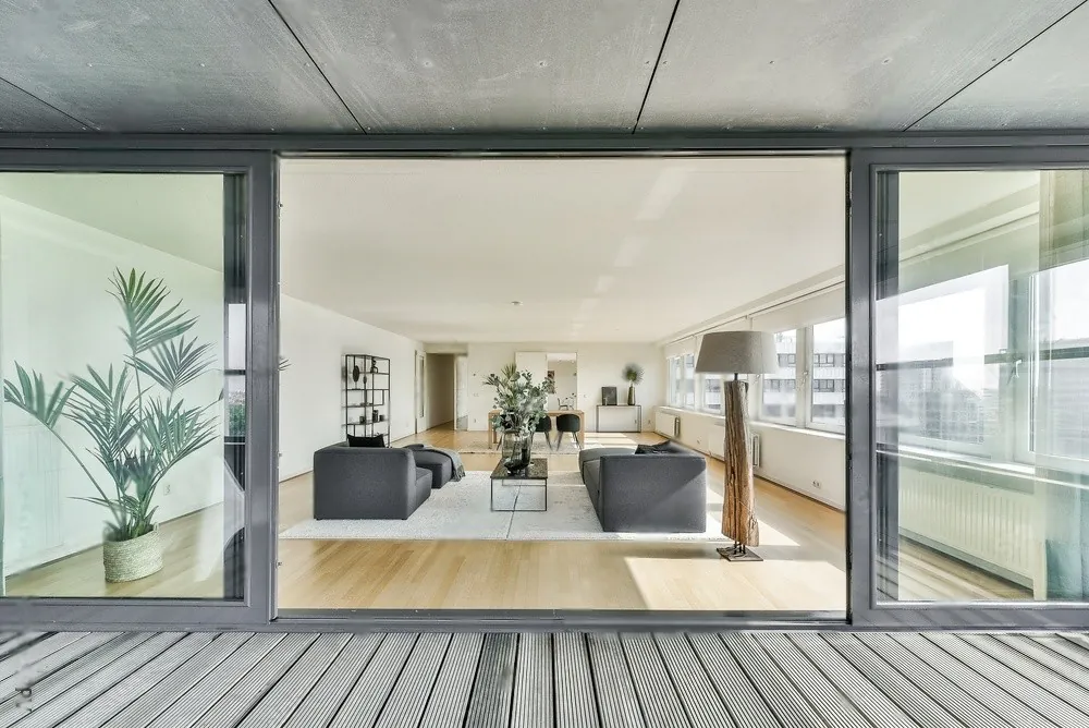A glass house opening onto a deck