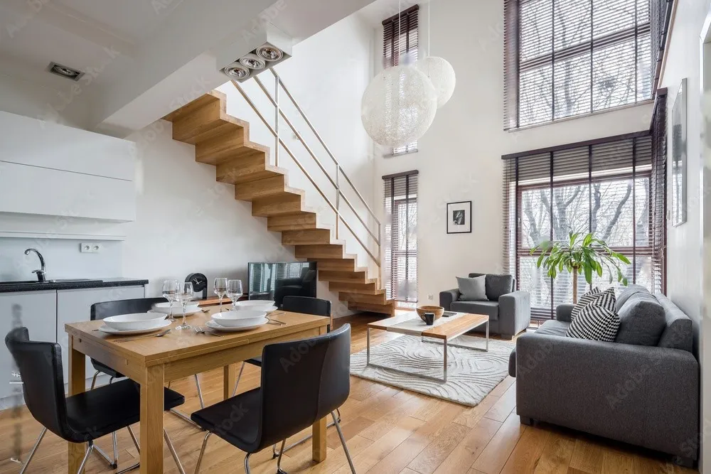 A dining table beside an open staircase