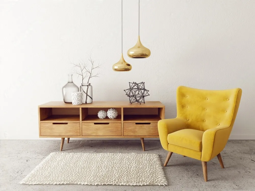 A yellow armchair beside a wooden sideboard