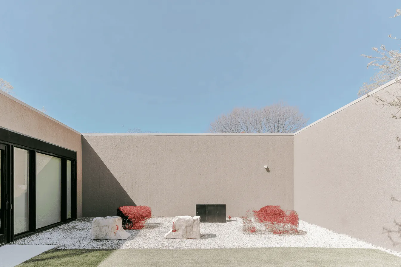 A white walled courtyard with red chairs