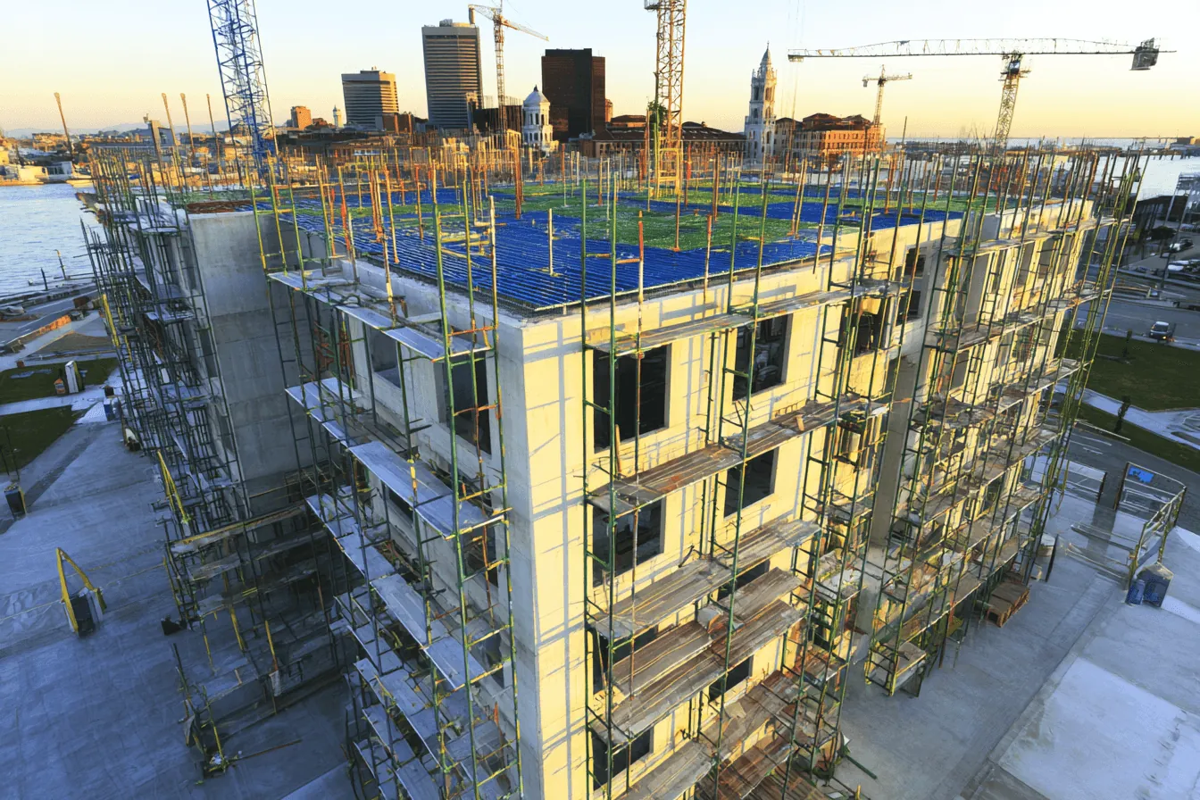 A building wrapped in scaffolding at sunset