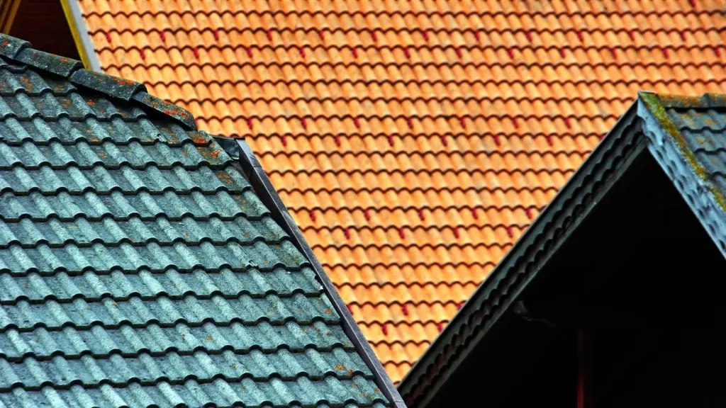 Teal and orange tiled roofs meeting at a gable