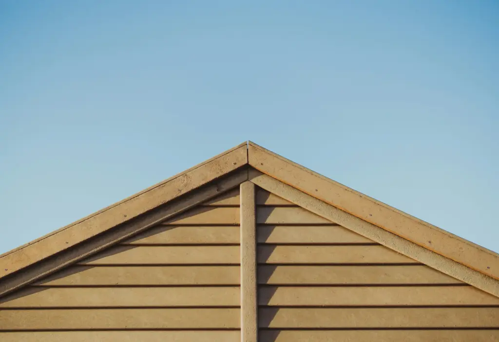 A timber-clad gable roof under a blue sky