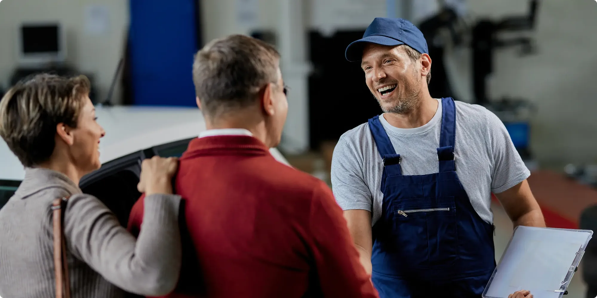 Smiling Gullwick plumber greeting a couple of homeowners