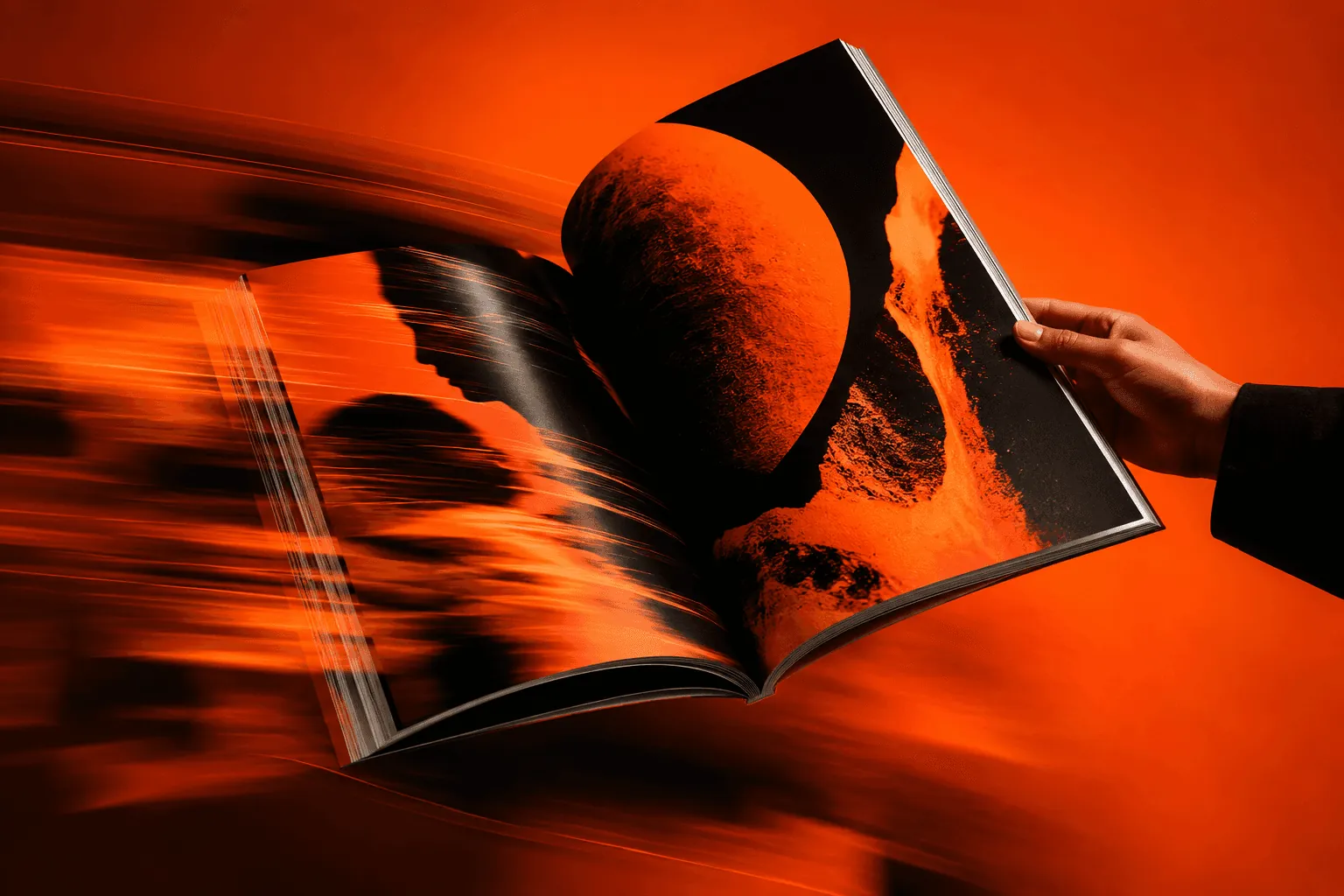 A hand holding an open journal against a blur of orange
