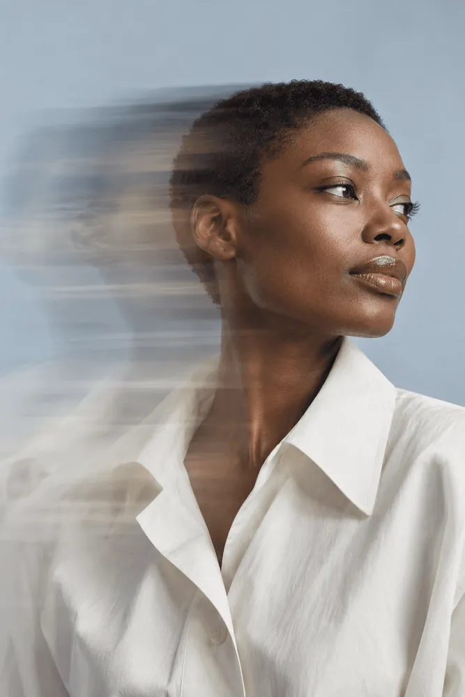 Editorial portrait against pale blue with a sweeping motion blur