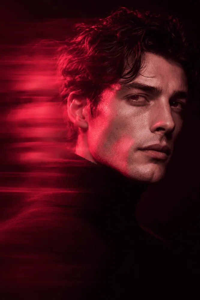 Editorial portrait lit in deep red with motion trails