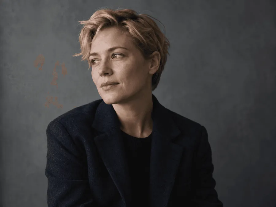A woman with short fair hair against a muted grey backdrop