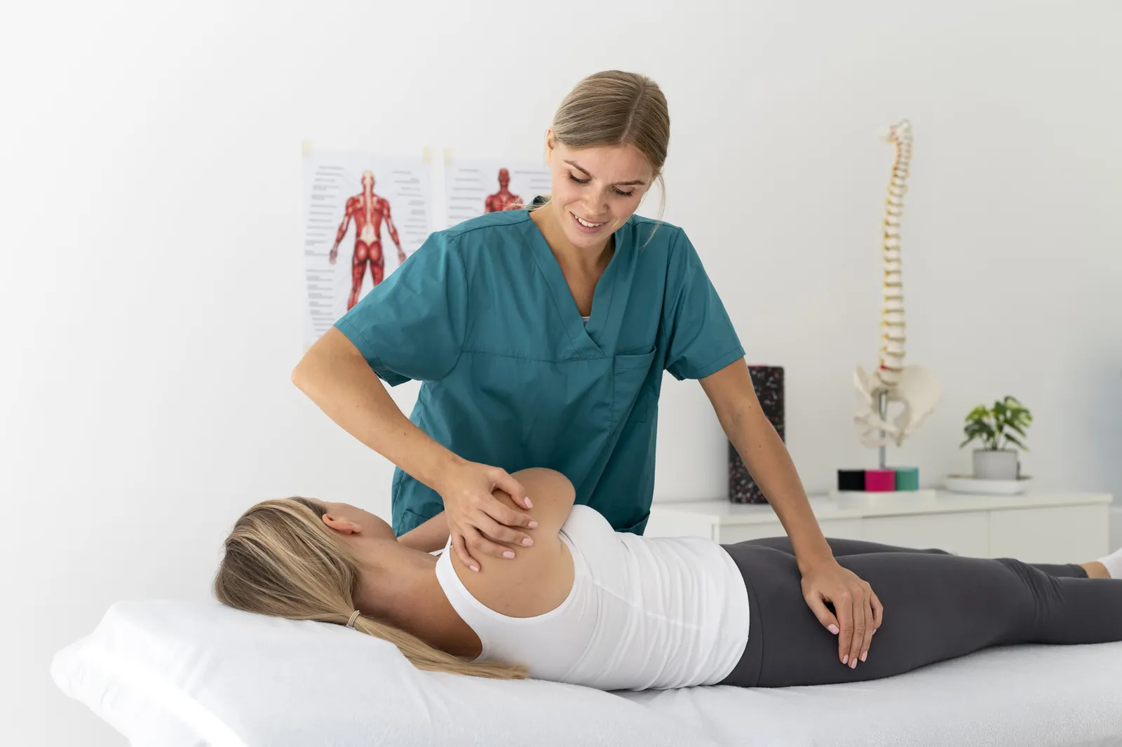 A chiropractor treating the lower back of a patient lying on her side