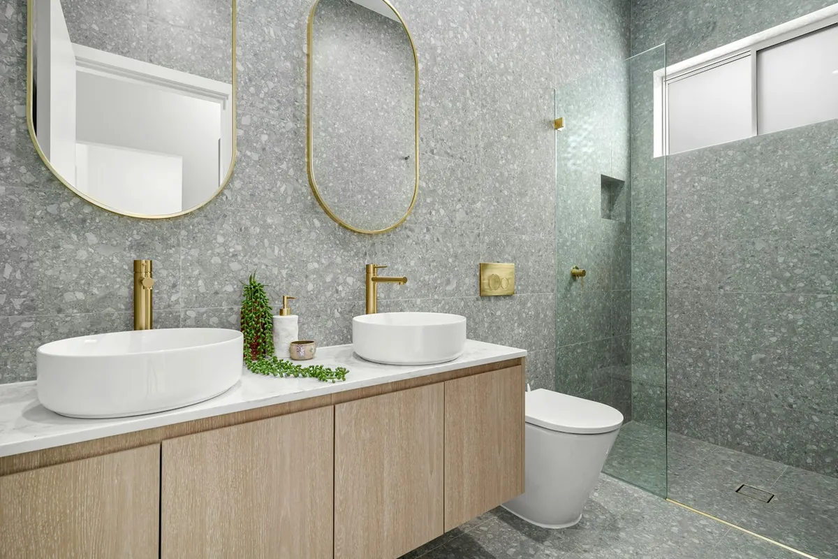 Two round basins on a pale oak vanity in a terrazzo bathroom