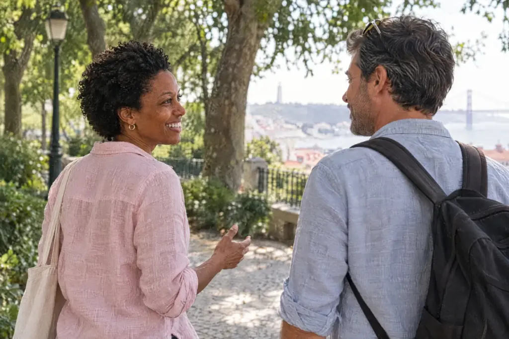 Iris walking and talking with a client along a leafy park path in Lisbon