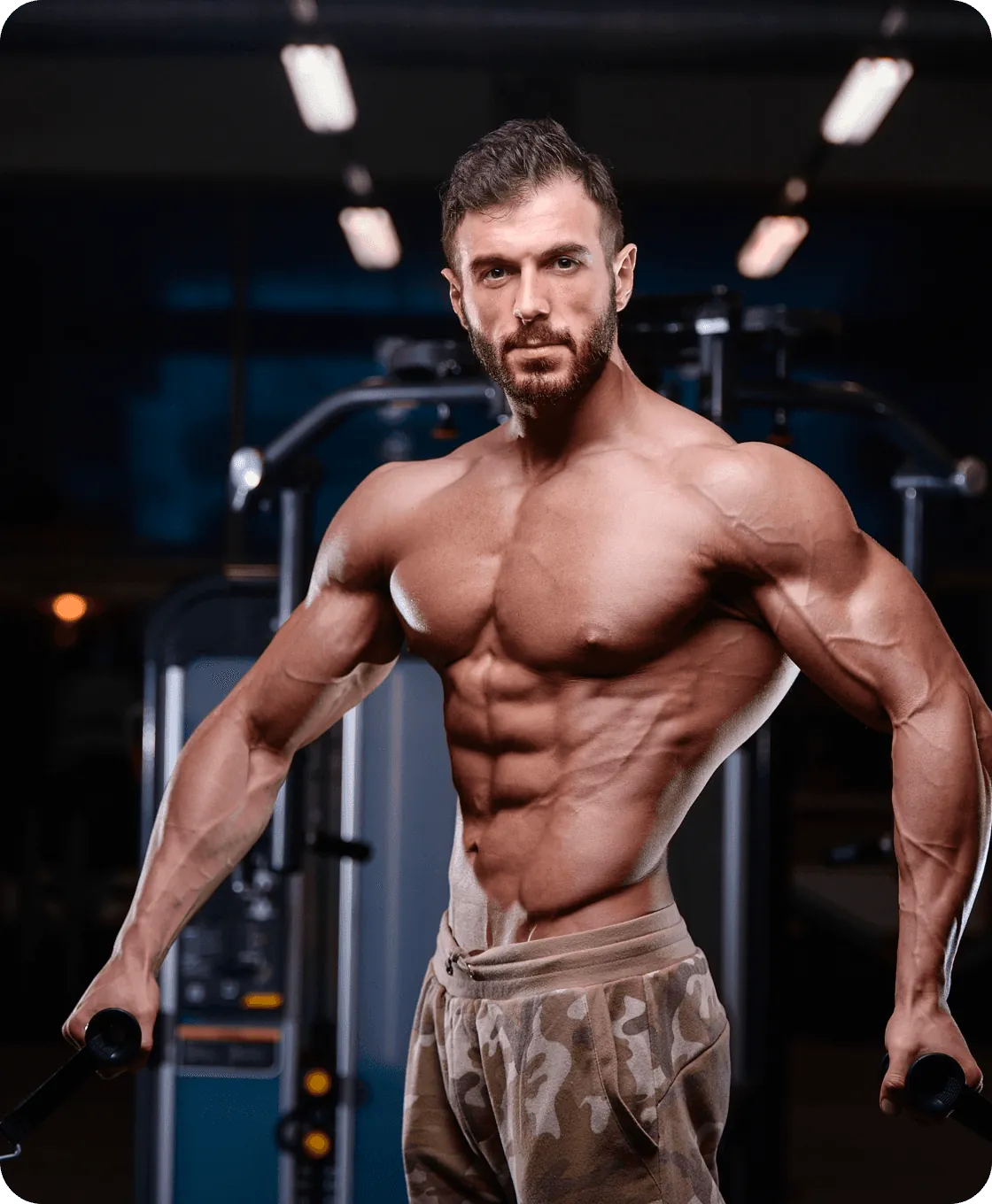 A muscular athlete between cable machines in the gym