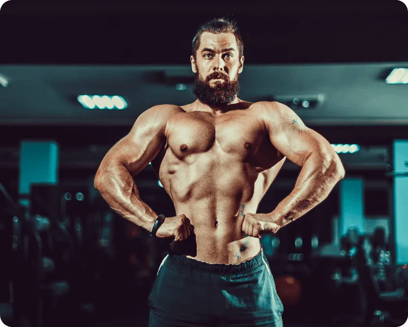 A muscular athlete posing in the gym