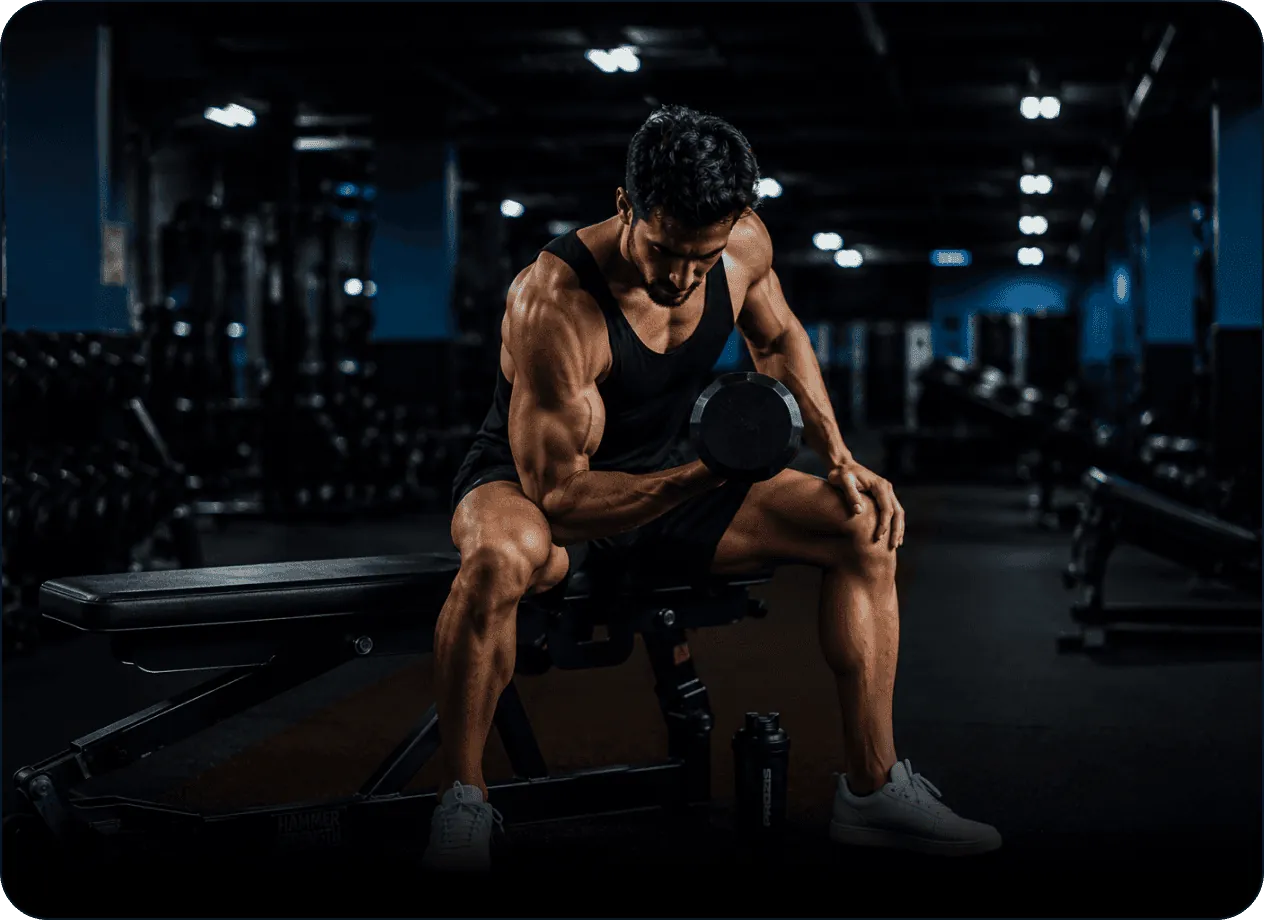 An athlete resting on a bench with dumbbells