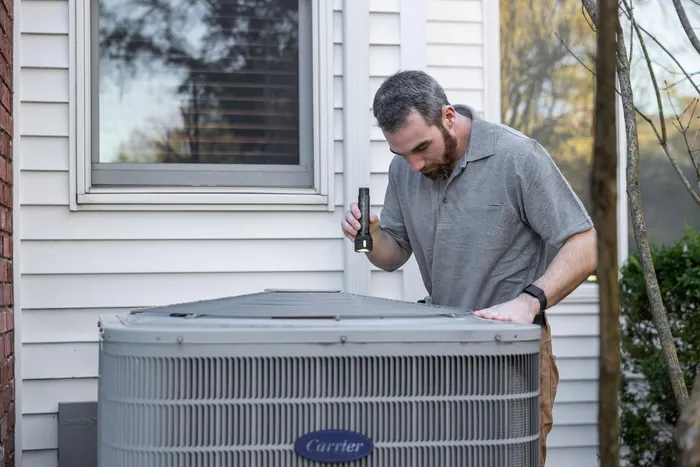 A technician checking an outdoor unit
