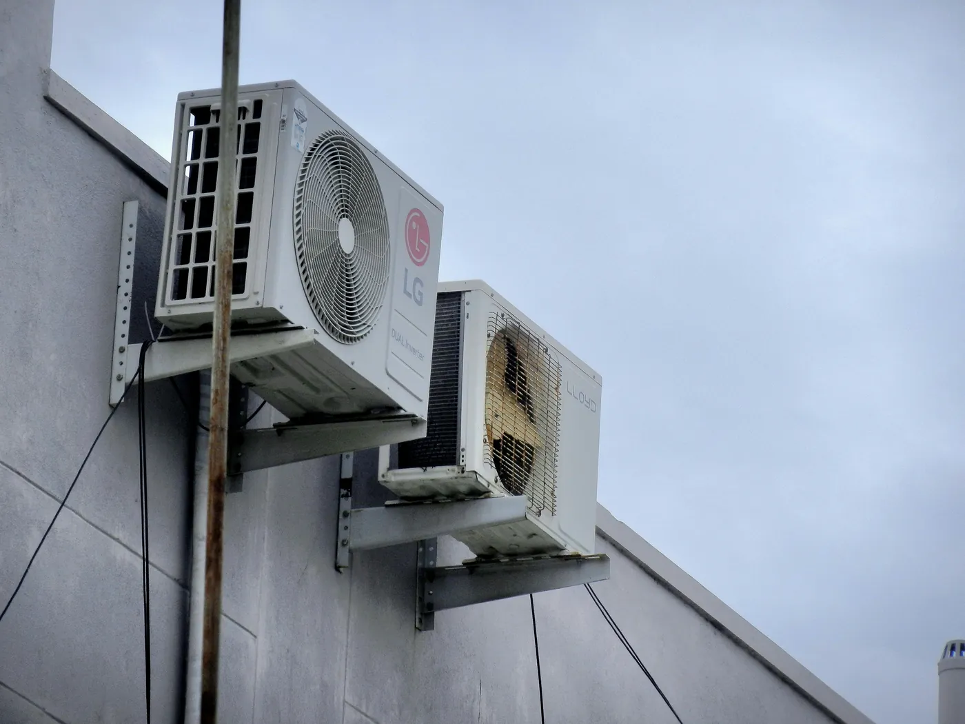 Two outdoor air conditioning units on a wall