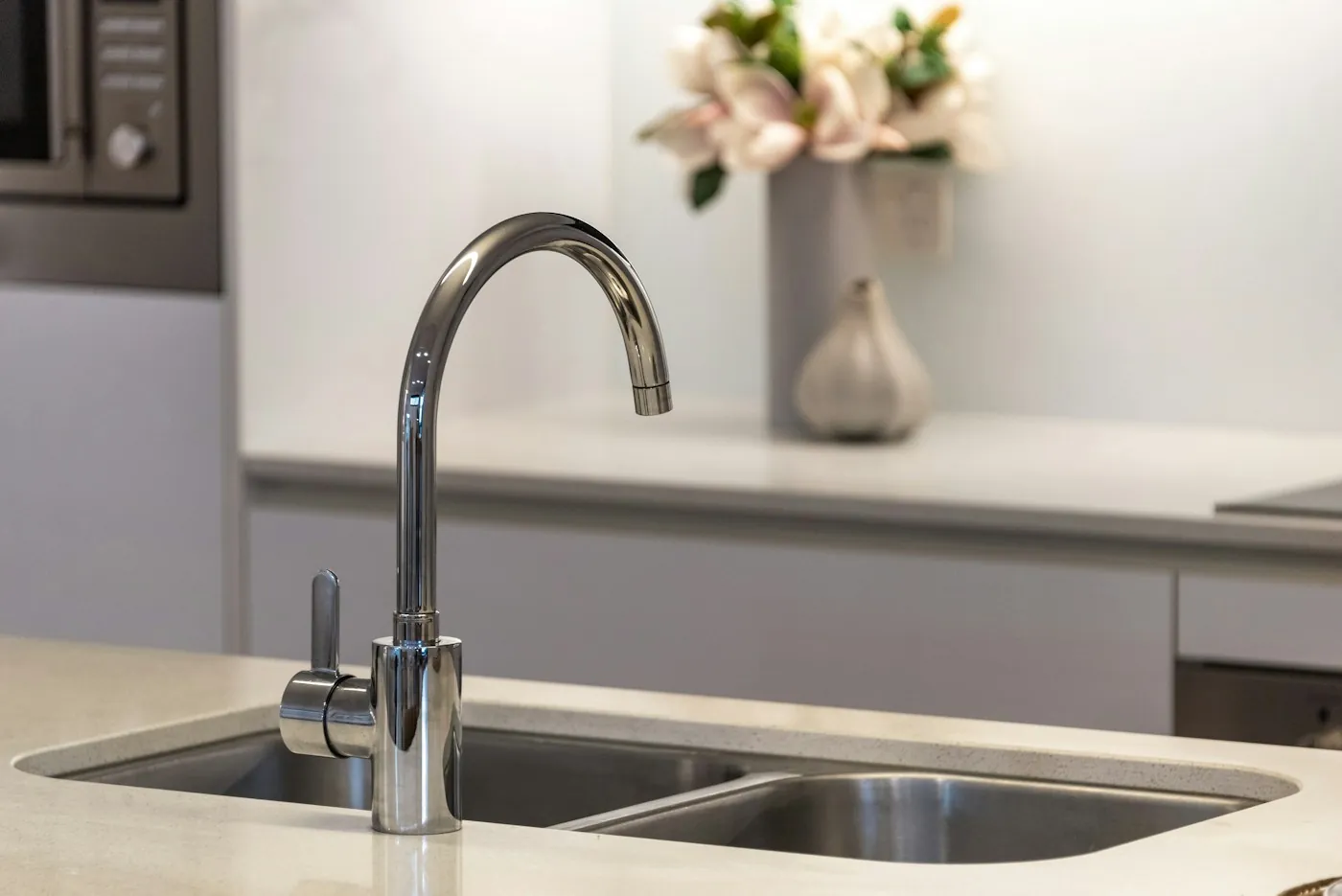 A new chrome kitchen faucet over a stone counter