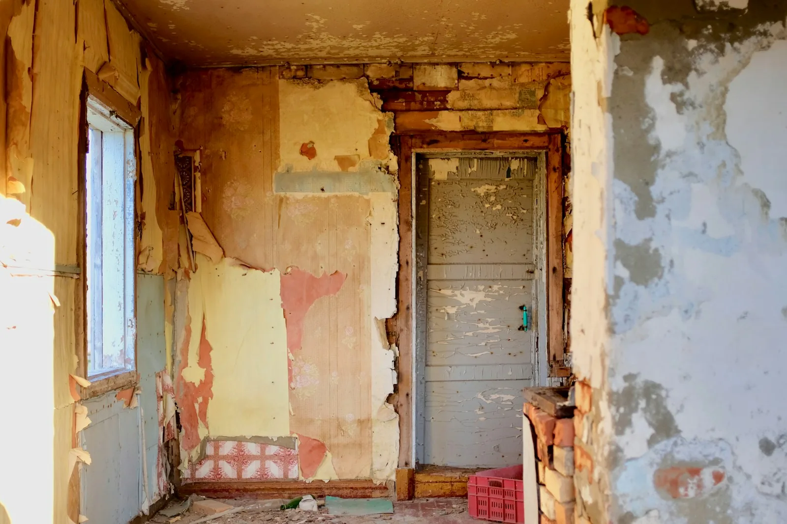 The bathroom before the work: peeling walls and an old door