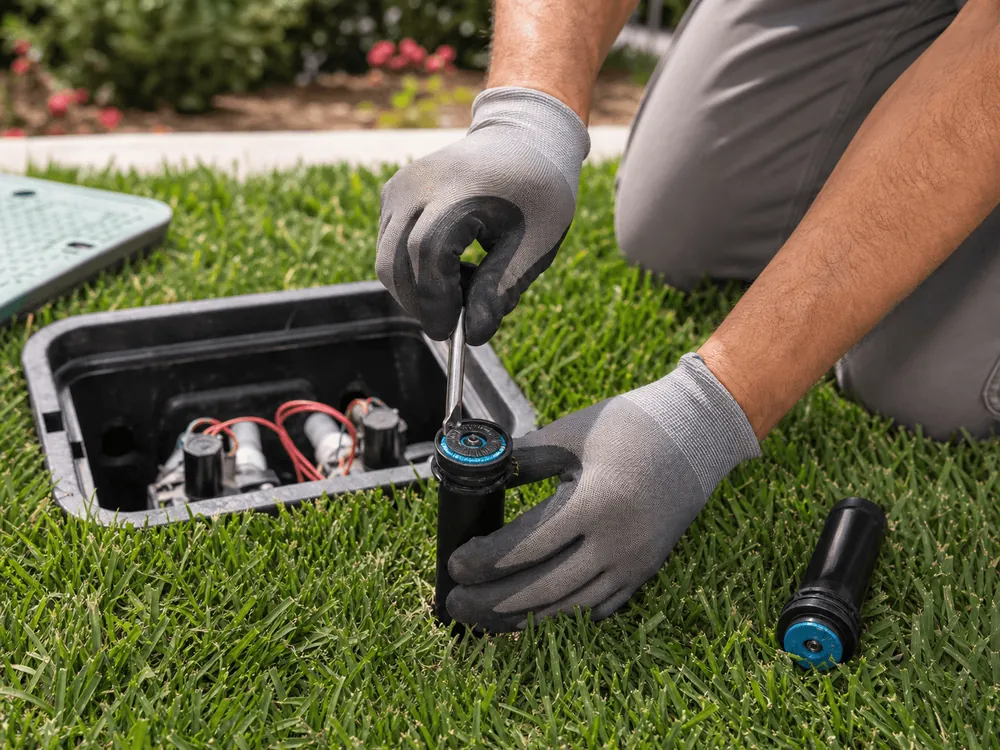 A technician repairing the valves in an irrigation box