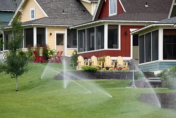 Sprinklers running across the front lawn of a house