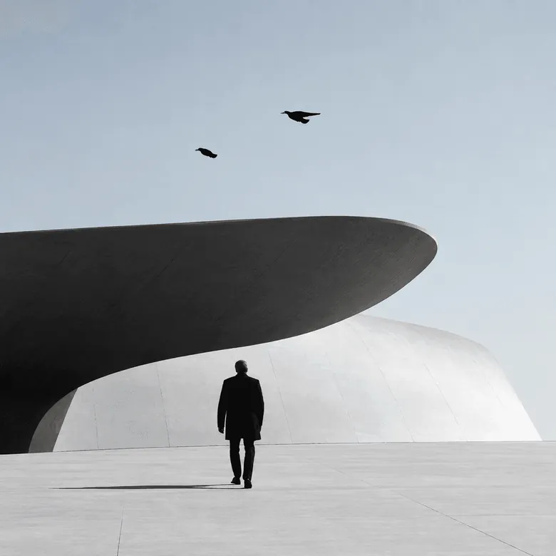 A figure walking under a white concrete dome