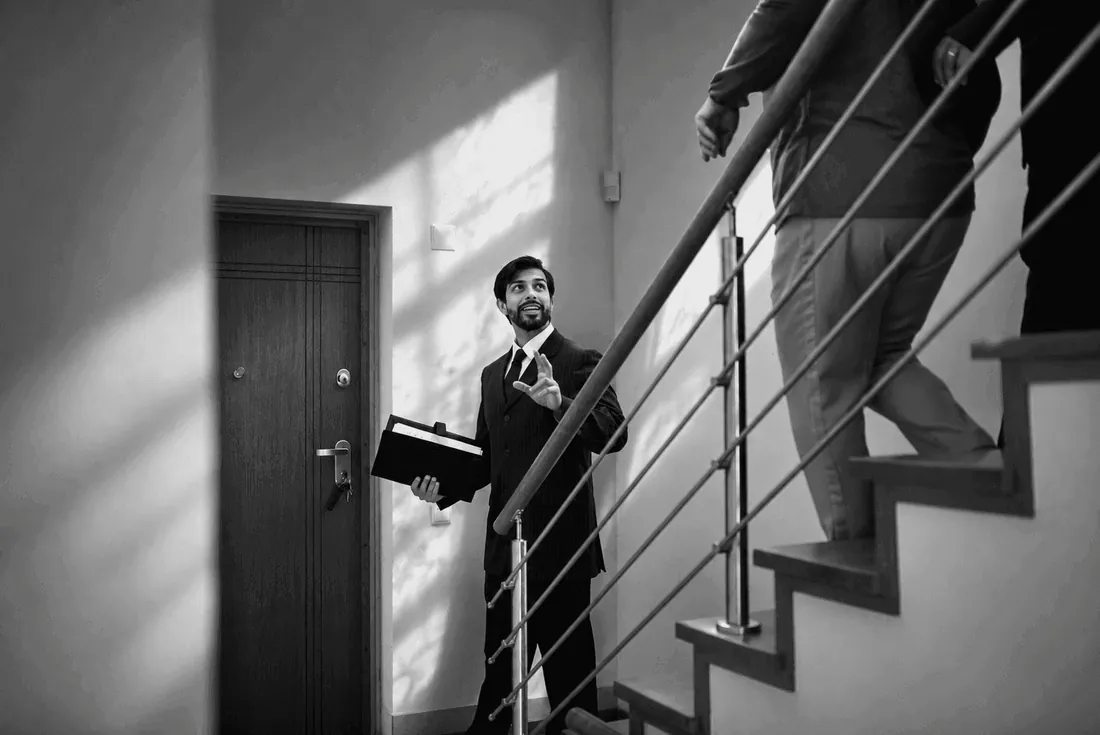 A man with a folder on a staircase by a door