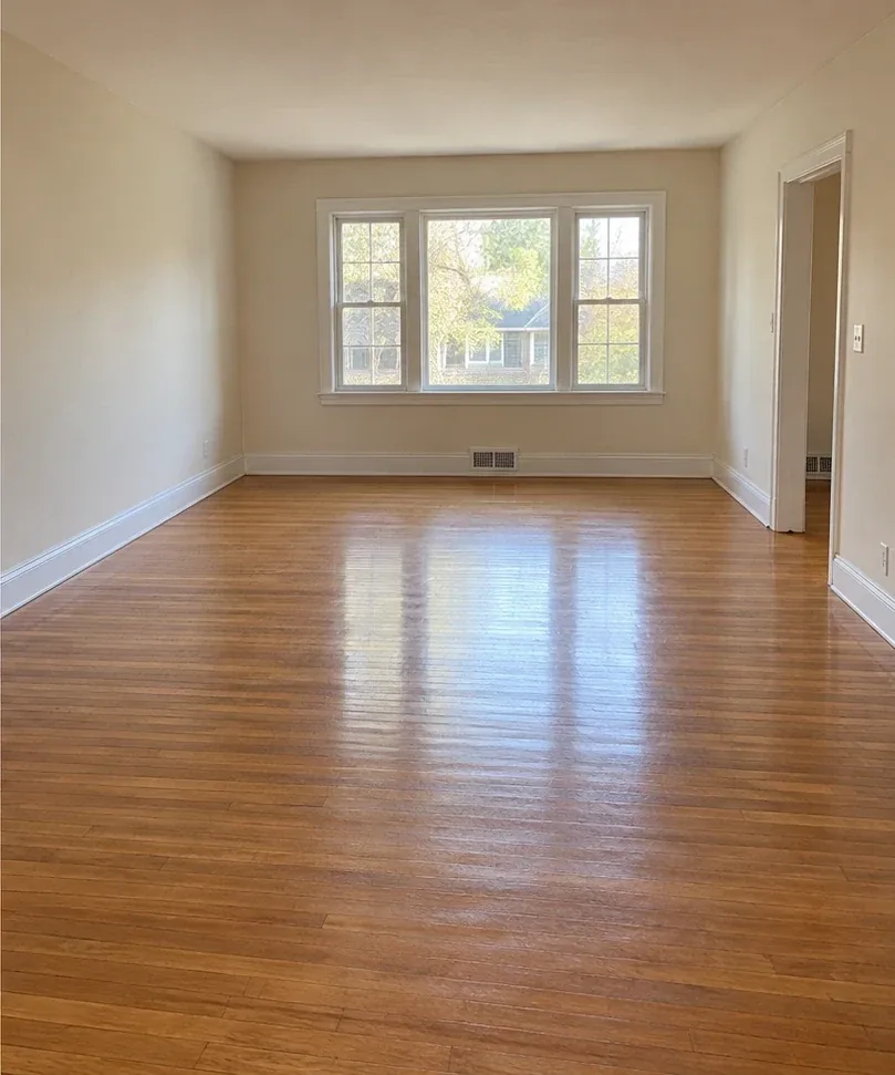 After: the same living room empty, with clean wooden floors.