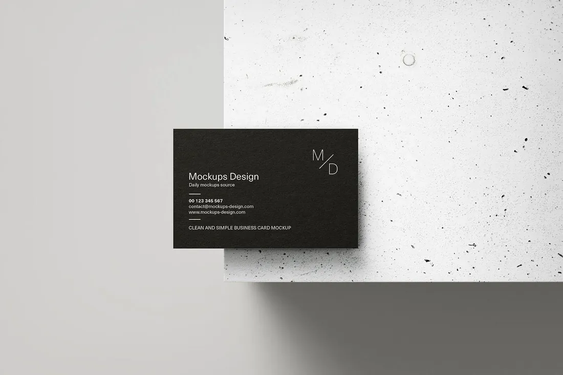 A black business card standing on a concrete ledge