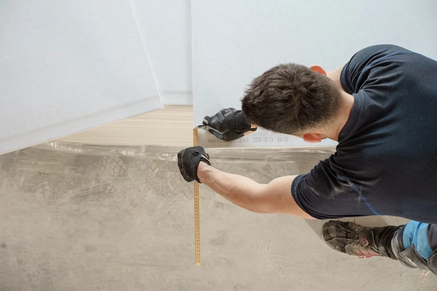 A worker measuring a concrete floor