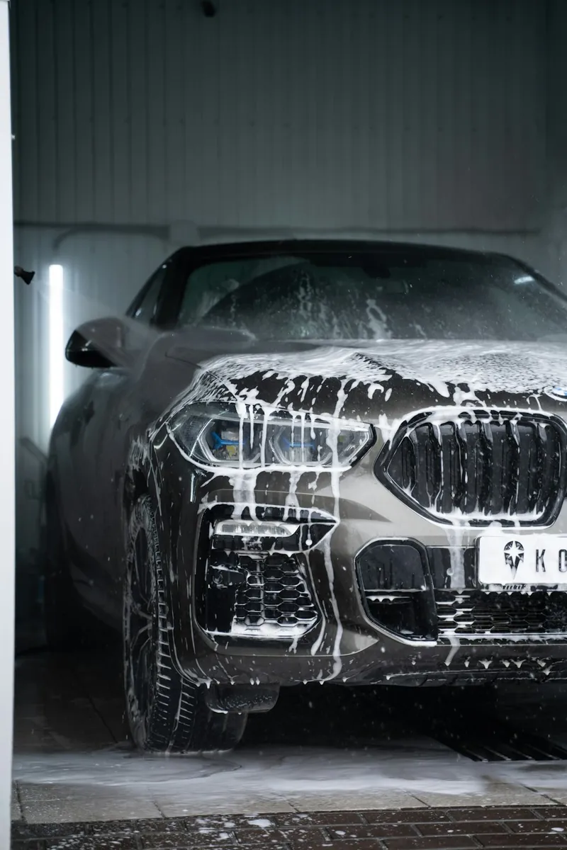 The front of a car covered in washing foam