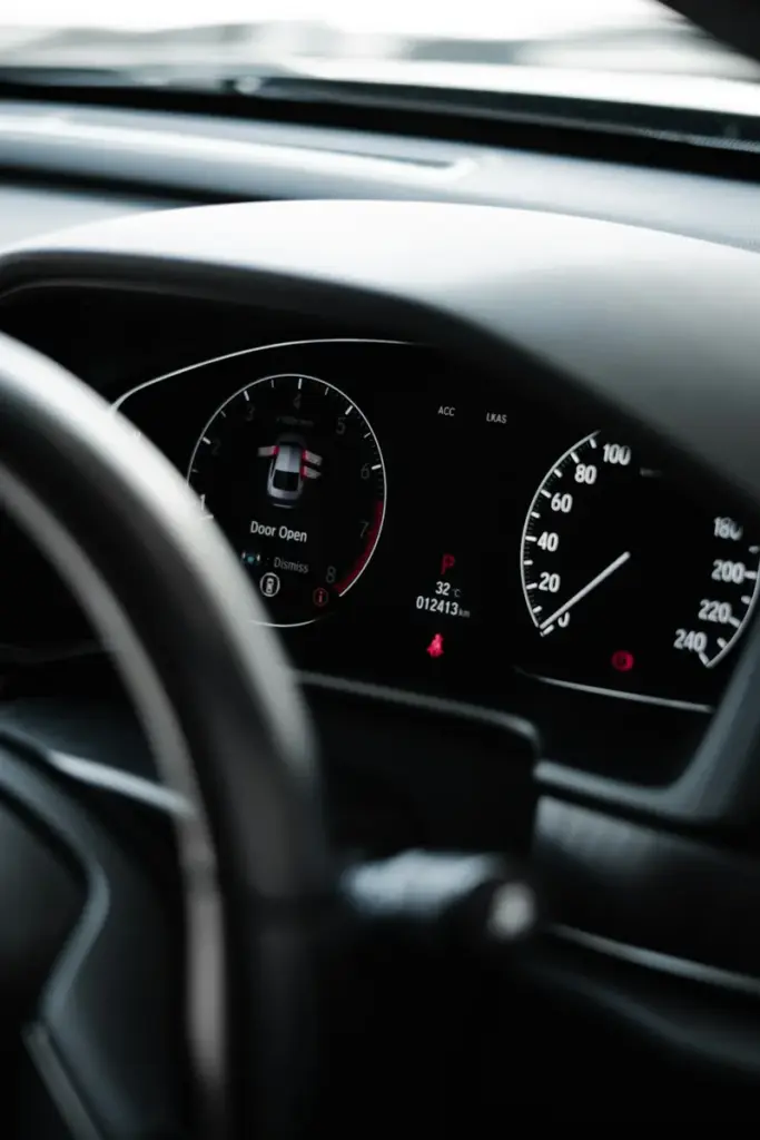 The lit speedometer and dials of a car dashboard