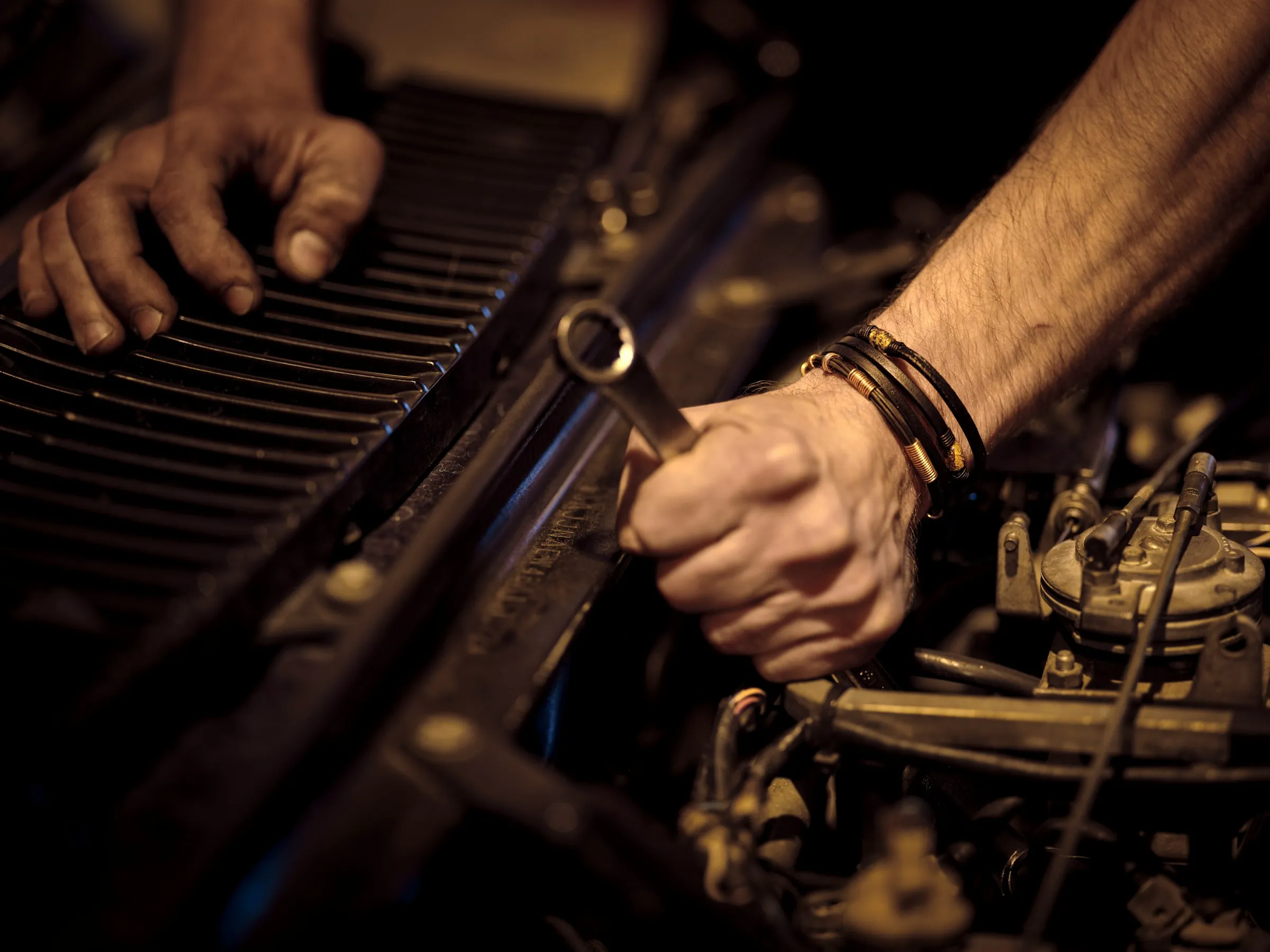 Hands with a wrench at work on an engine
